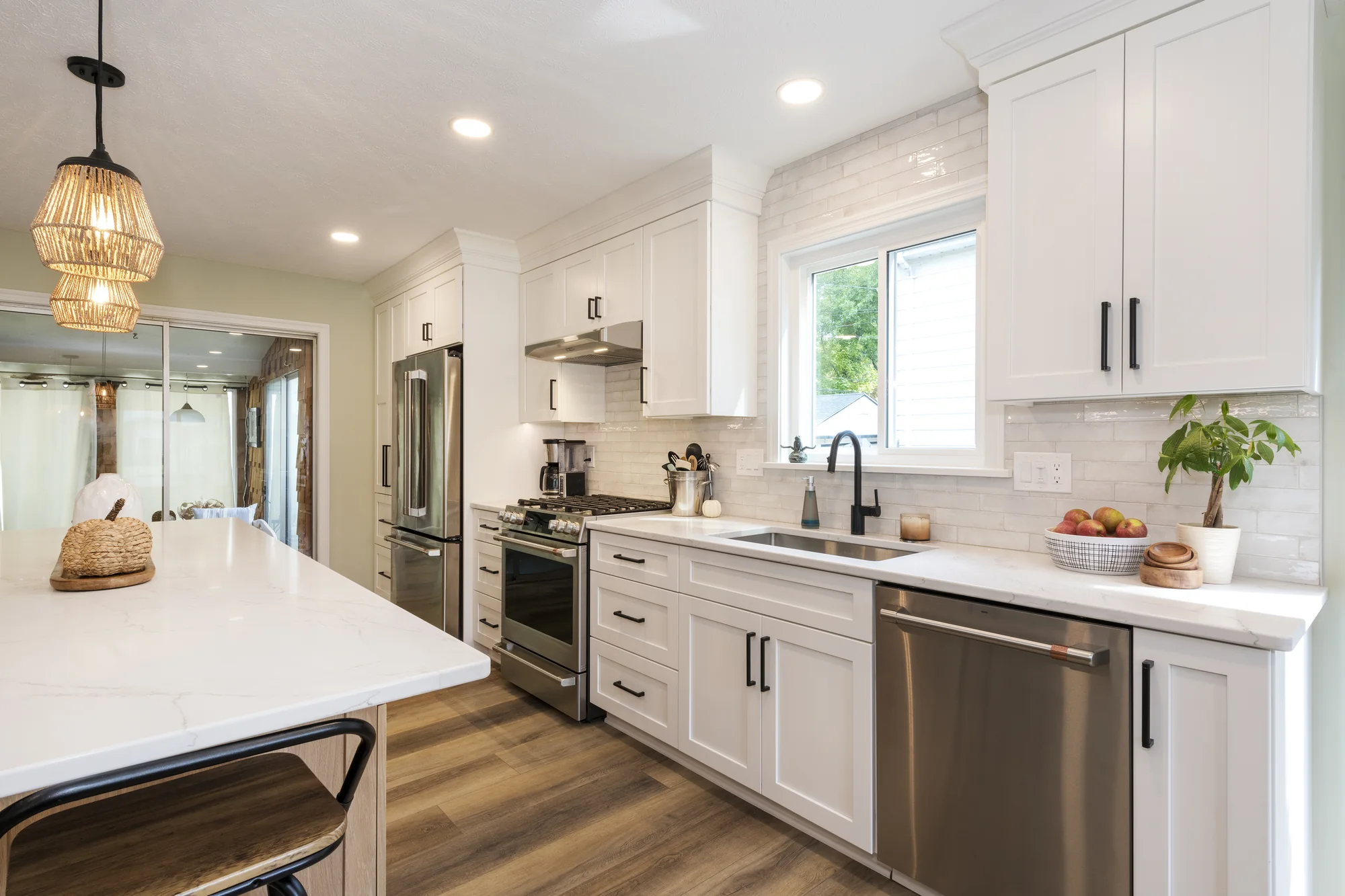 White kitchen cabinetry along the sink and range walls